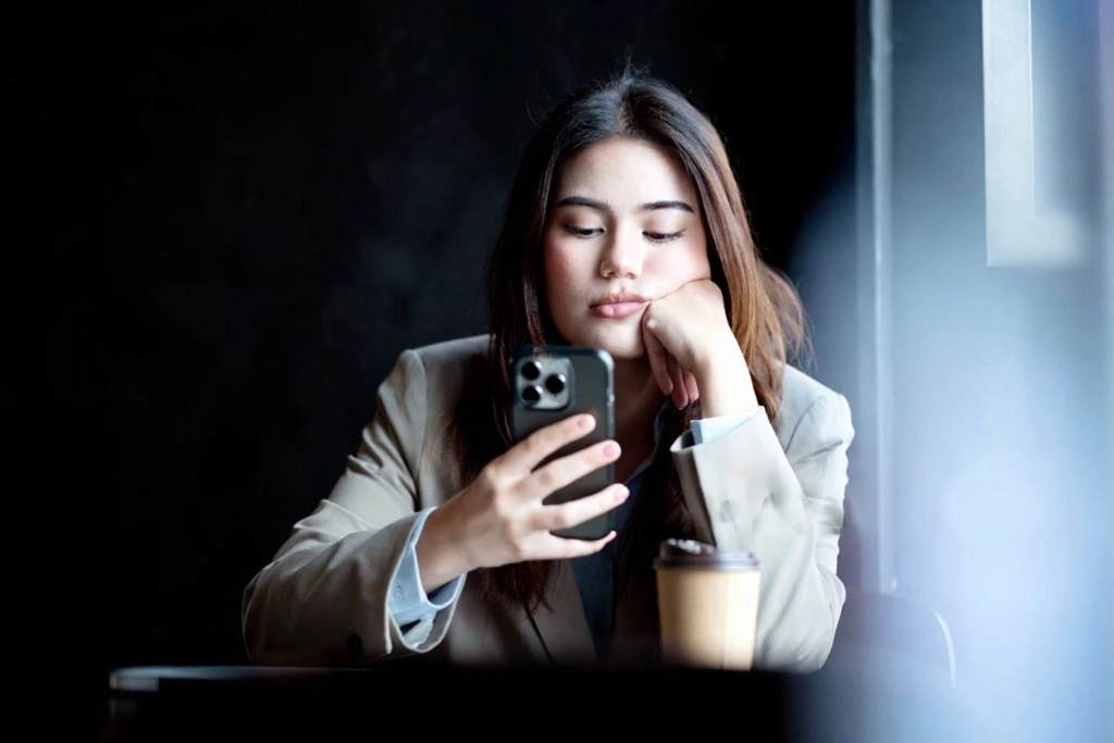 A patient looking exhausted while waiting on hold to reach a family doctor